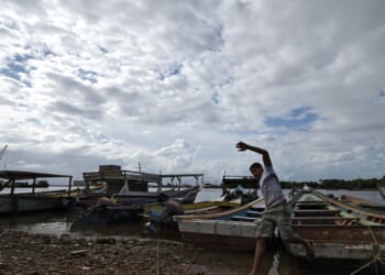 A fisherman prepares to sail off from an artisanal dock and participate in the search for victims of a shipwreck in Guiria, Venezuela, on Dec. 18, 2020.