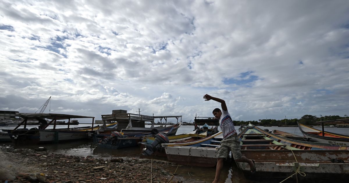 A fisherman prepares to sail off from an artisanal dock and participate in the search for victims of a shipwreck in Guiria, Venezuela, on Dec. 18, 2020.