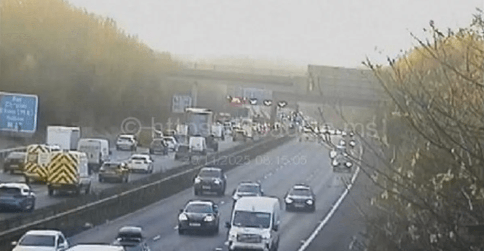 CCTV image showing heavy traffic on a multi-lane motorway with cars backed up due to an incident ahead.