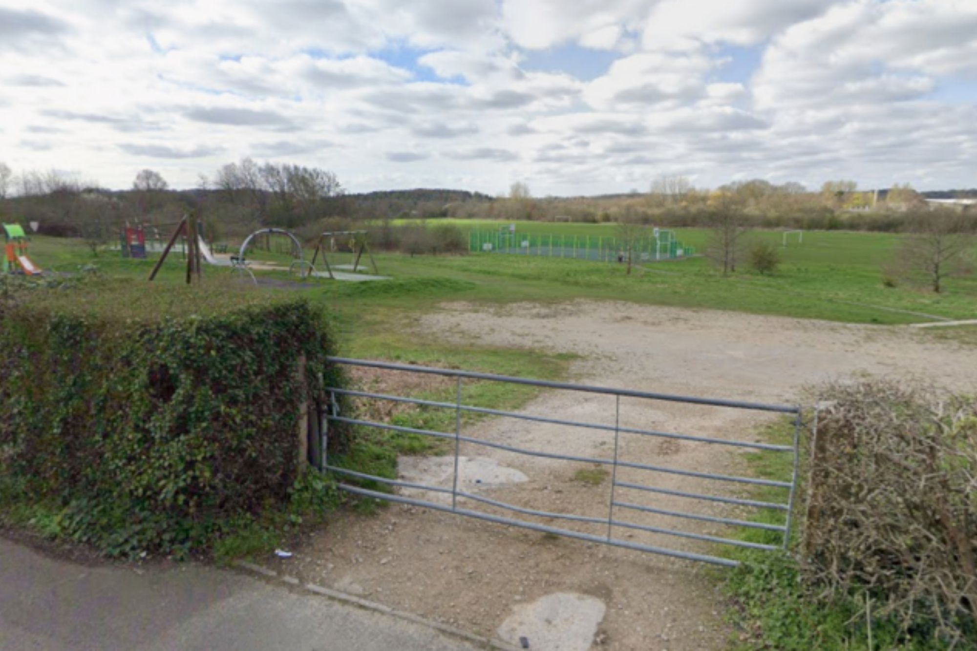 An image collage containing 1 images, Image 1 shows An open metal gate leading to a playground and sports fields