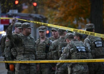 National Guard soldiers stand behind the crime scene tape at a corner in downtown Washington, D.C., on Nov. 26, 2025.