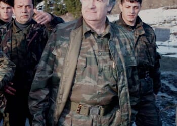 Bosnian Serb wartime leader, Radovan Karadzic, walks accompanied by bodyguards