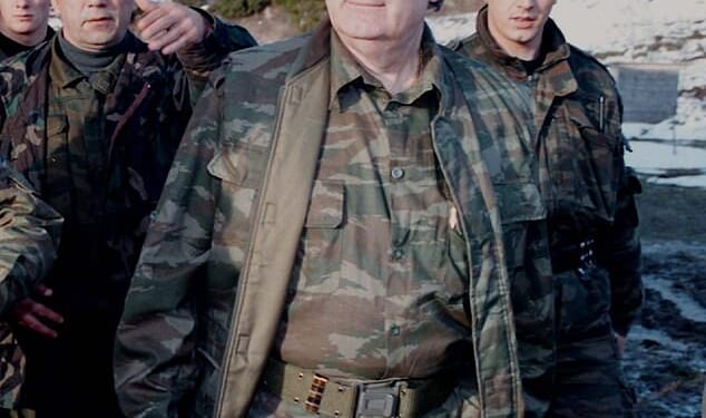 Bosnian Serb wartime leader, Radovan Karadzic, walks accompanied by bodyguards