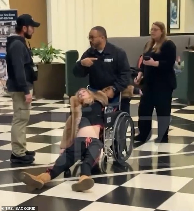 Reid, 50, slipped out of the wheelchair as a security guard manoeuvred her through the lobby