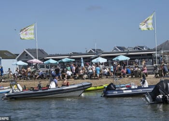 Wealthy beach hut owners claim The Beach House, pictured, is turning their pristine stretch of coast into a 'Magaluf rave scene'