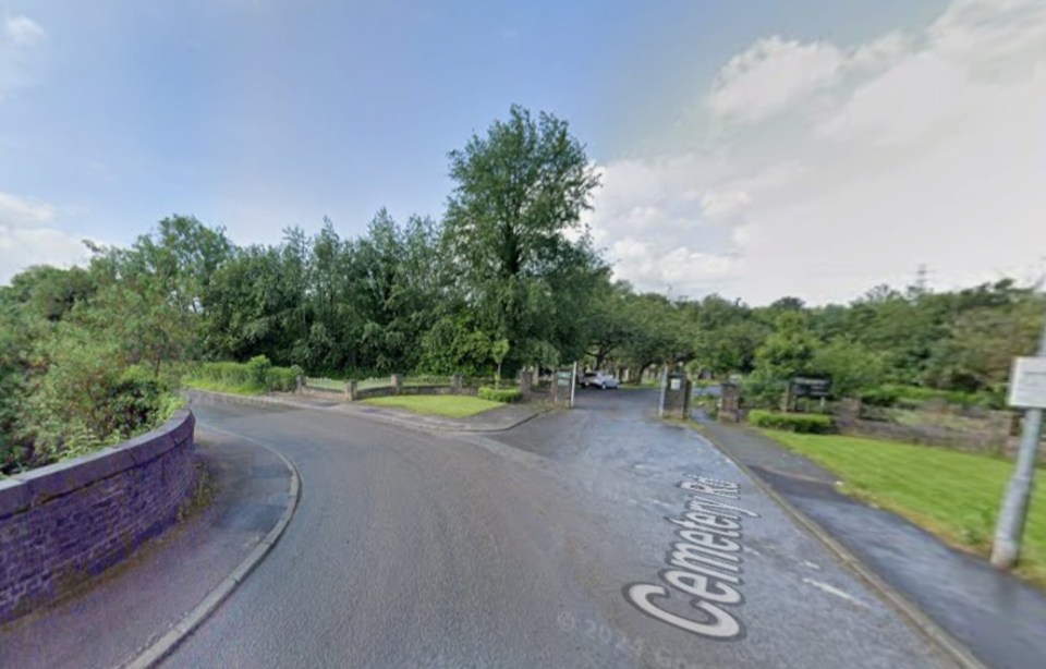 A road labeled "Cemetery Road" leading to a cemetery entrance with trees.