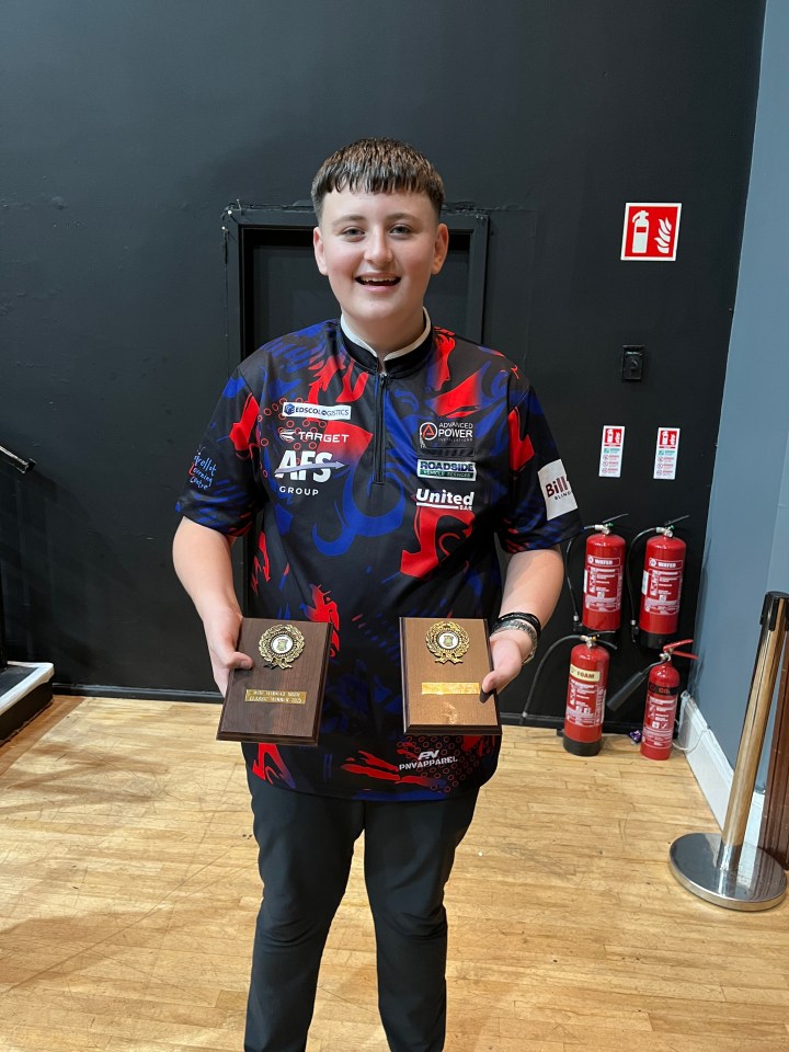 Mitchell Lawrie holding two trophies from the Irish Classic darts tournament.