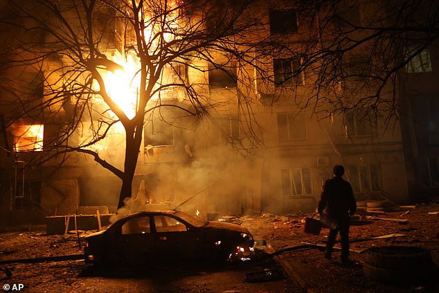 A man walks in front of burning residential building after a Russian attack on Zaporizhzhia, Ukraine, Wednesday, Nov. 26, 2025
