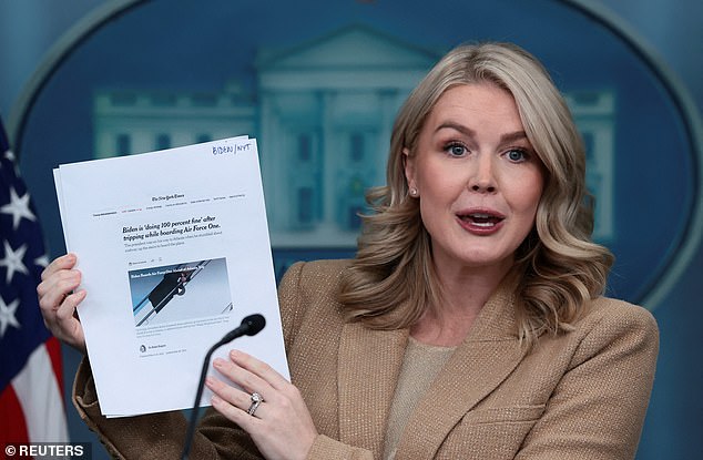White House Press Secretary Karoline Leavitt holds a printed article from The New York Times titled 'Biden is doing 100 percent fine after tripping while boarding Air Force One' as she revealed the results of Trump's MRI on Monday