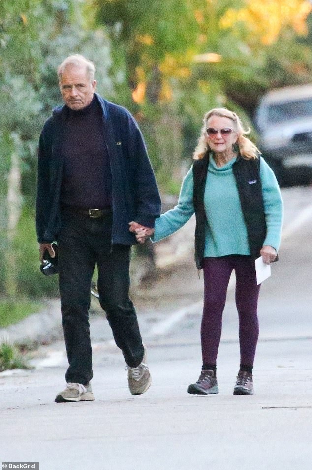 Maxwell lovingly held his wife's hand as they made their way down the road