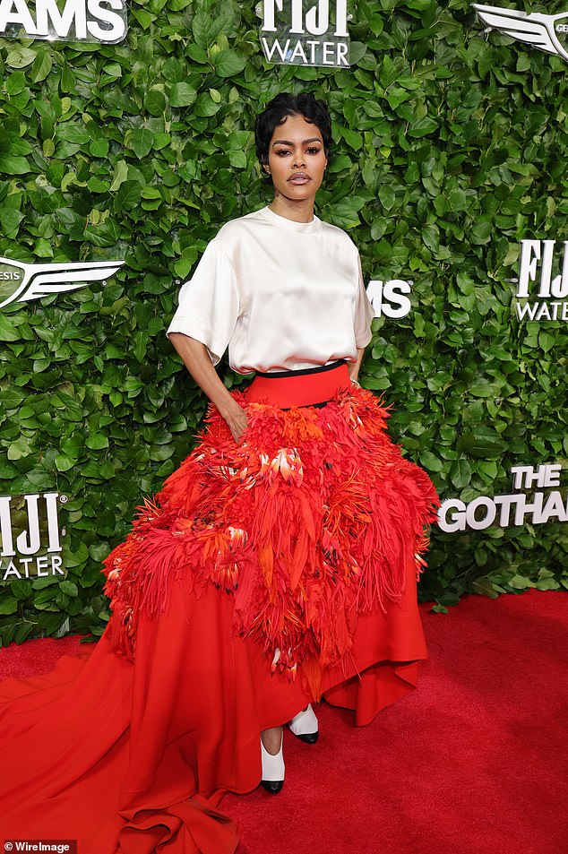Teyana Taylor also went for the apparent theme of feathers for the Gotham Film Awards as she walked the red carpet in a voluminous crimson skirt with structured hip bustles for an exaggerated silhouette