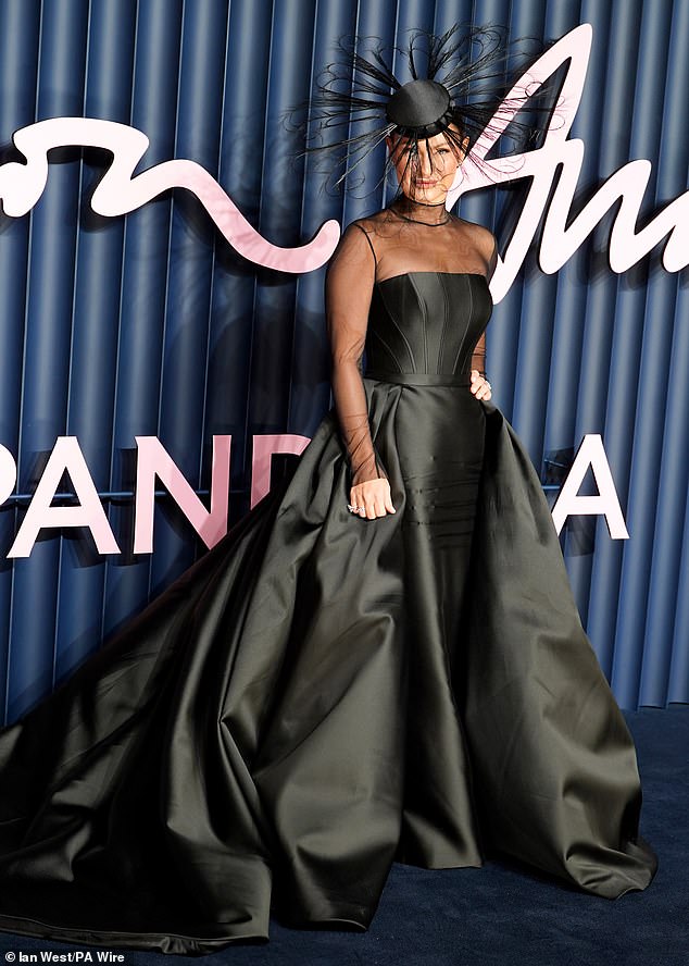 She completed the look with a kooky head pieces with huge feathers while her blonde locks were hidden beneath the hat