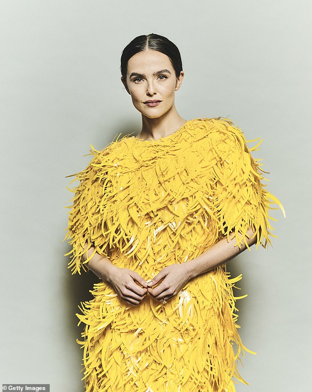 Zoey Deutch posed stoically in her wild yellow frock before heading inside to mingle with fellow stars