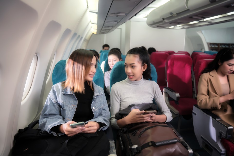 People flying by plane ,Passengers waiting for take-off . Interior of airplane with passengers on their seats.