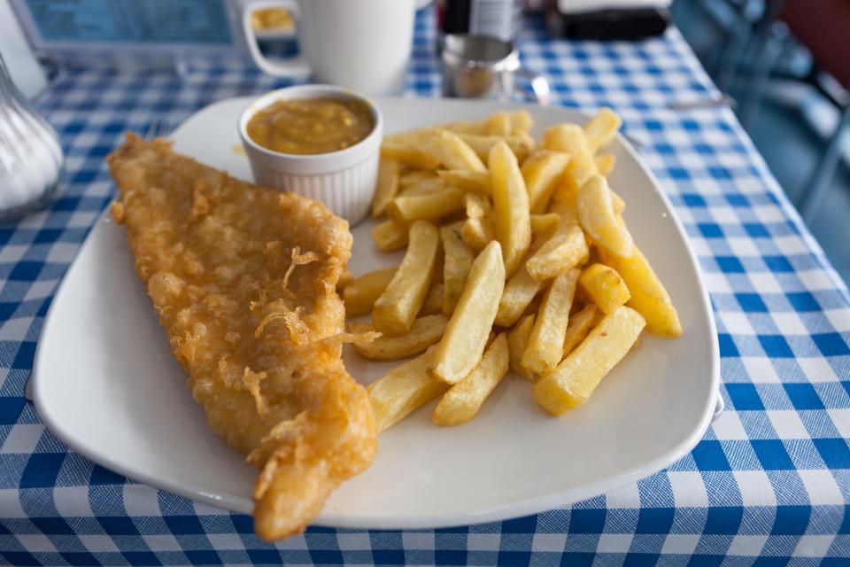 Traditional British fish and chips with curry sauce.