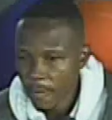 Close-up of a man with short dark hair and a light-colored hoodie.