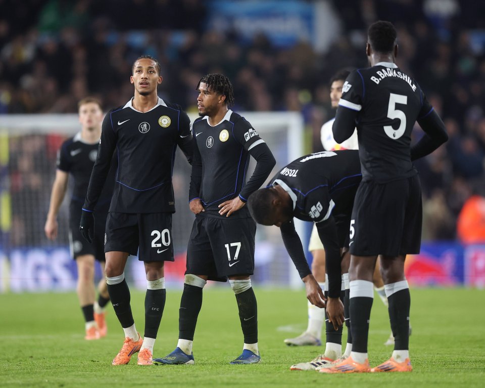 Chelsea FC players on the pitch, looking disappointed after a play.