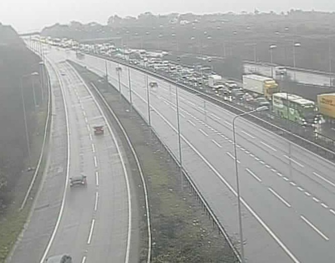 Motorway with heavy traffic congestion on the right lanes and lighter traffic on the left lanes.