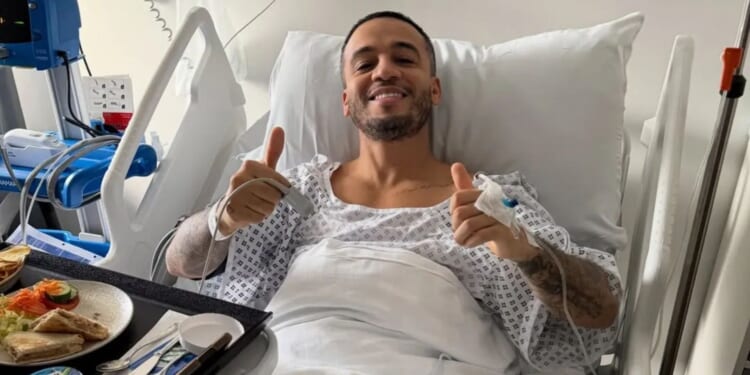 JLS star gives fans health update as he shares photo from hospital bed after operation