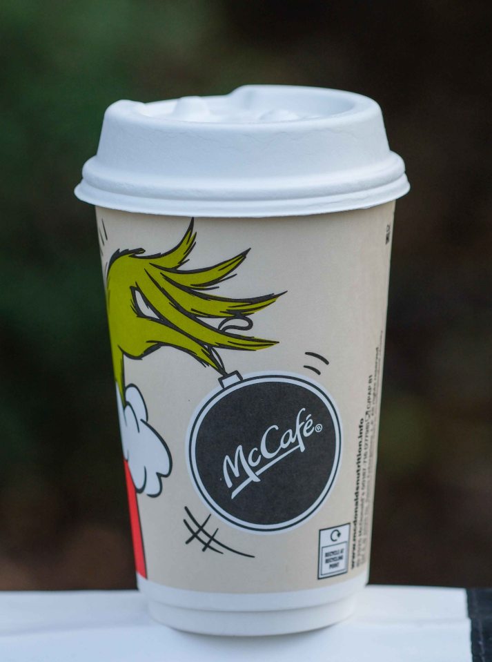 McCafé coffee cup with a Christmas-themed design and a plastic lid.