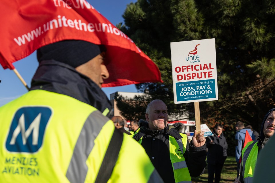 Ground staff from Menzies Aviation holding "Official Dispute" signs at a picket line.