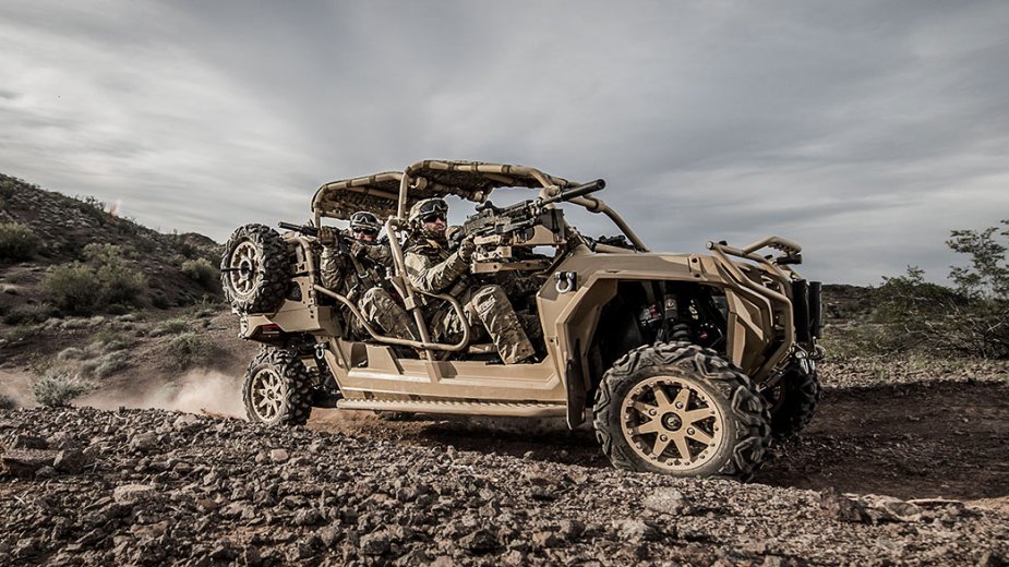 Polaris MRZR-series all-terrain dune buggy carrying two soldiers in desert camouflage.