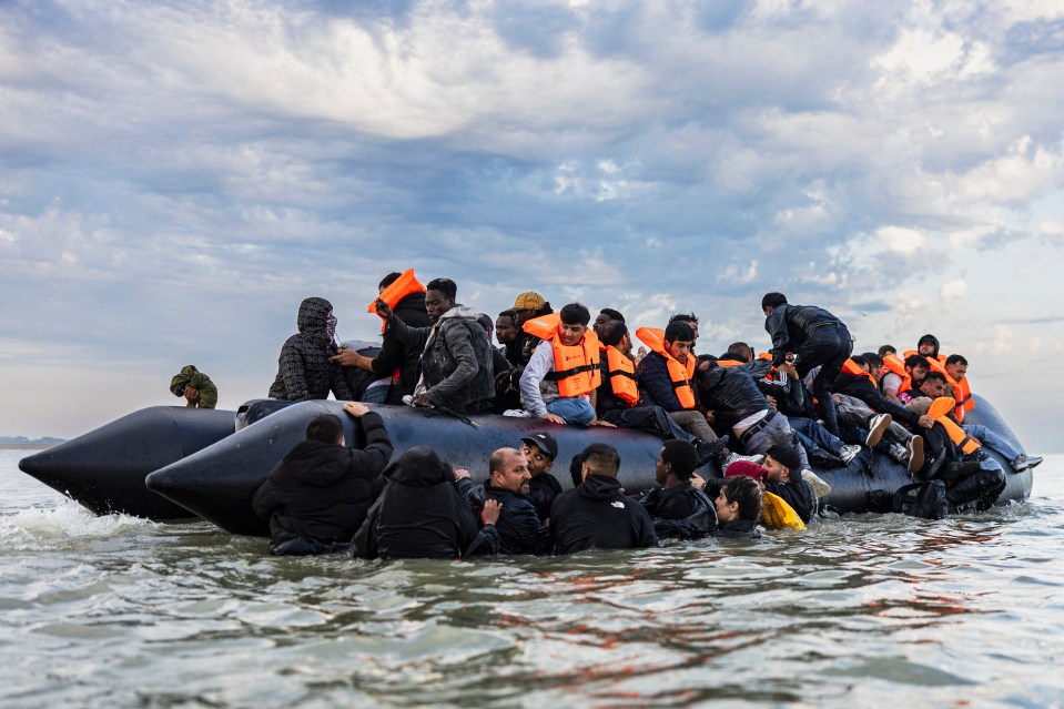 Migrants attempting to board a smuggler's boat to cross the English Channel.