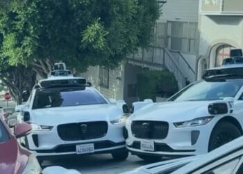 Excruciating moment three self-driving taxis clog up street and stop moving after getting into AI standoff