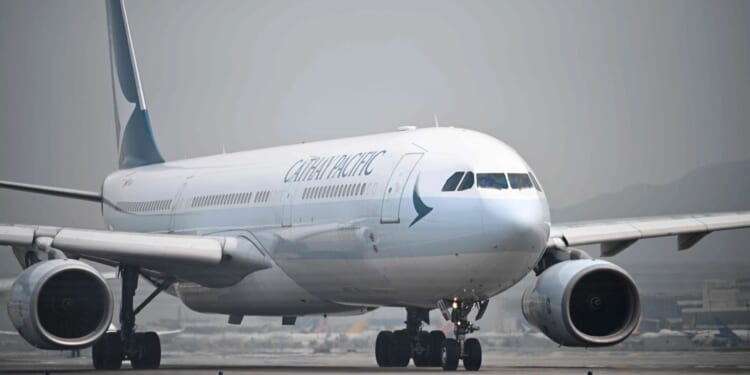Passenger, 20, arrested after trying to open plane's door mid-air on Cathay Pacific flight