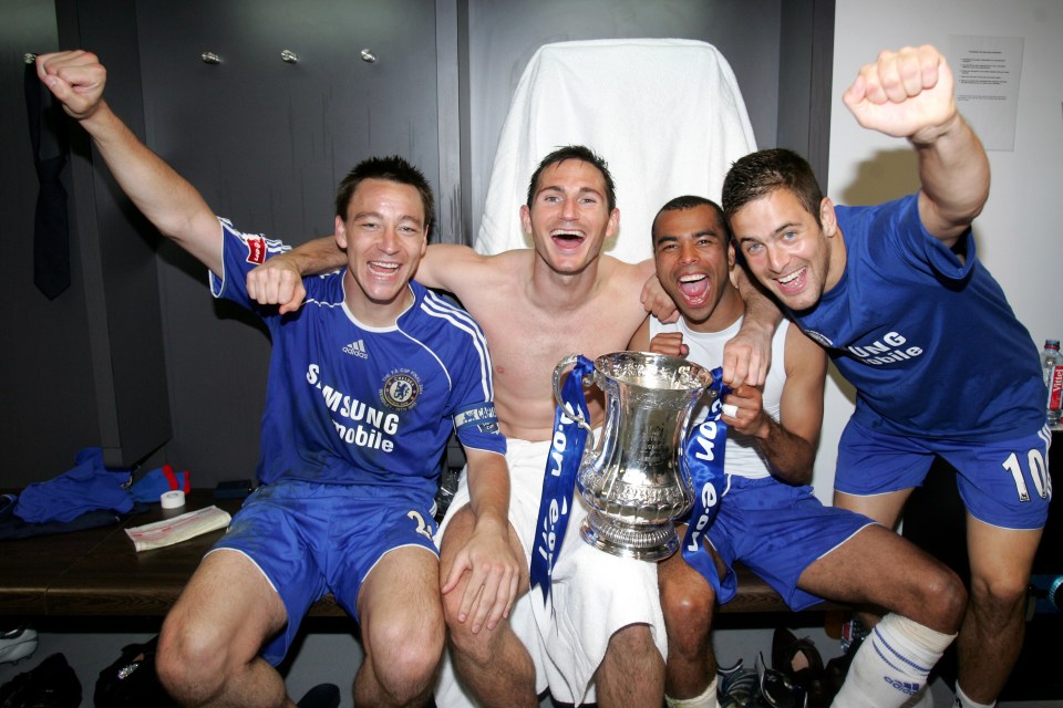 Chelsea players John Terry, Frank Lampard, Ashley Cole, and Joe Cole celebrate with the FA Cup in the locker room.
