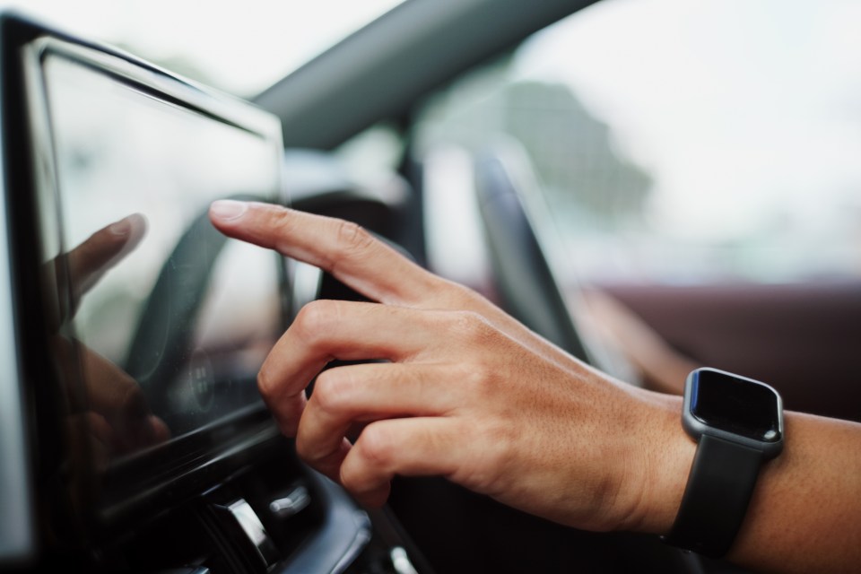 Man checking map gps or control music radio in car.