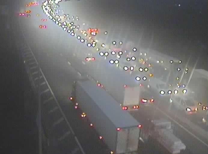 Overhead view of a highway at night, showing heavy traffic with car lights and truck lights visible.