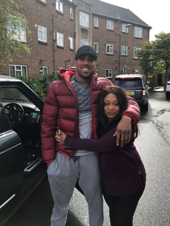 Anthony Joshua hugging his mother in front of an ex-council flat.