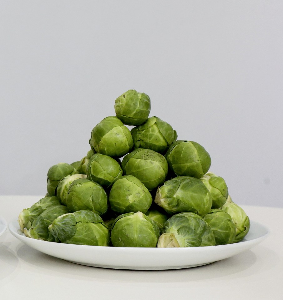A plate full of green Brussels sprouts.