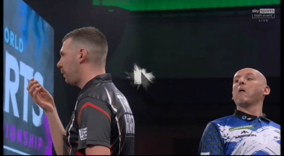 Two men playing darts in a competition.