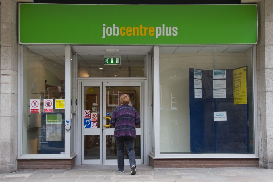 A woman walks towards the doors of a Jobcentre Plus in Shrewsbury.