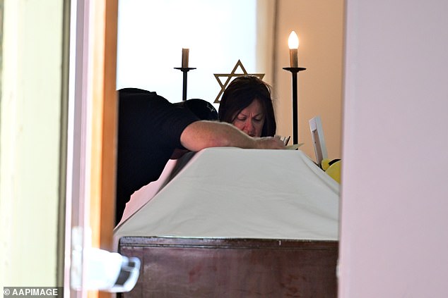 A man drapes himself over the casket during the funeral for 10-year-old Matilda at Chevra Kadisha Memorial Hall in Sydney, Thursday, December 18, 2025. Australia is in mourning after gunmen opened fire on Bondi Beach, killing 15 people in an attack designed to target the Jewish community. (AAP Image/Dean Lewins) NO ARCHIVING