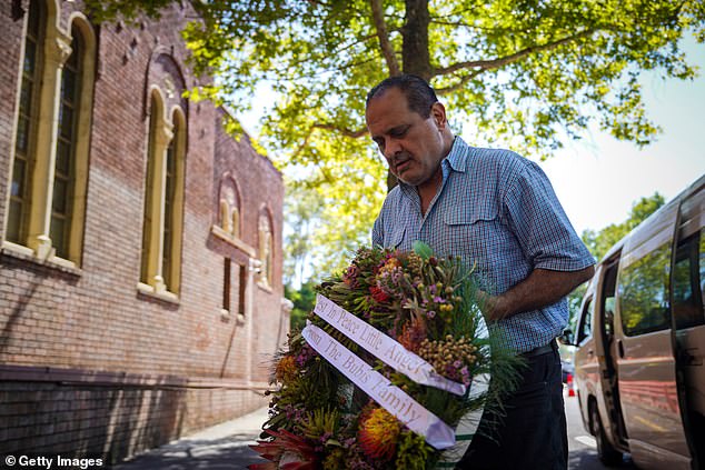 SYDNEY, AUSTRALIA - DECEMBER 18: Mourners arrive with flowers outside the location of the funeral 10-year-old Matilda, on December 18, 2025 in Sydney, Australia. Matilda, who was ten years old, was among the victims of a mass shooting that took place on Bondi Beach on Sunday. Police say at least 16 people, including one suspected gunman, were killed and more than 40 others injured when two attackers opened fire near a Hanukkah celebration at the world-famous Bondi Beach, in what authorities have declared a terrorist incident. (Photo by Audrey Richardson/Getty Images)