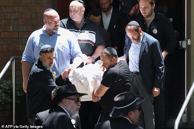 Mourners carry the coffin of 10-year-old Matilda out of the memorial hall