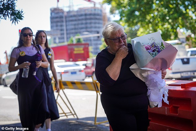 Some mourners carried large bunches of flowers to the funeral service on Thursday (pictured)