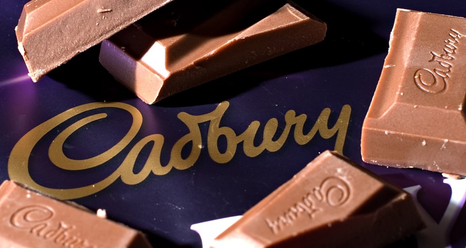 Pieces of Cadbury chocolate and the Cadbury logo on a purple background.
