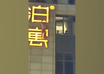 Shocking moment ‘secret lover’ dangles from hotel sign in just boxers after ‘escaping out window to avoid being spotted’