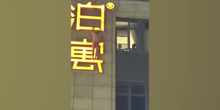Shocking moment ‘secret lover’ dangles from hotel sign in just boxers after ‘escaping out window to avoid being spotted’