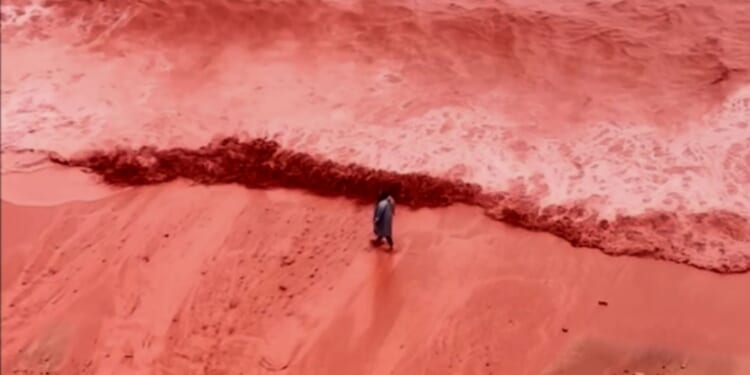 Haunting moment ‘blood rain’ weather phenomenon turns beach bright RED