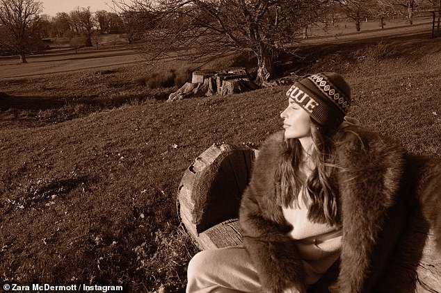 She kept warm in a winter hat while relaxing on a wooden bench in the countryside