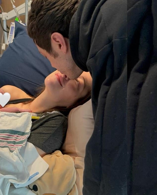 In a photo that looked to be taken shortly after delivery, Davidson leaned over to kiss Hewitt as she held their newborn daughter against her body