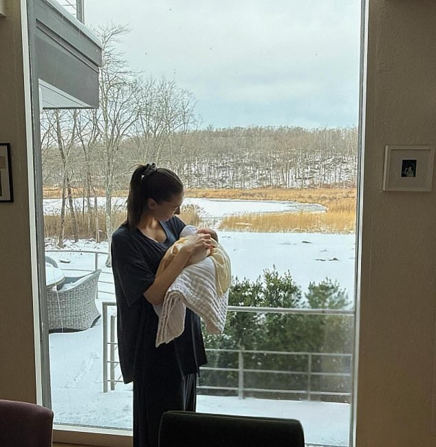 Another photo showed Hewitt gazing down at Scottie as she held her in front of a large window