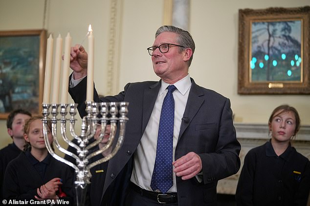 Sir Keir Starmer lights a candle during a Downing Street event to mark Hanukkah. The PM admitted many Jewish people have told him that anti-Semitism has been 'normalised' and they now have to 'hide their Jewish identity
