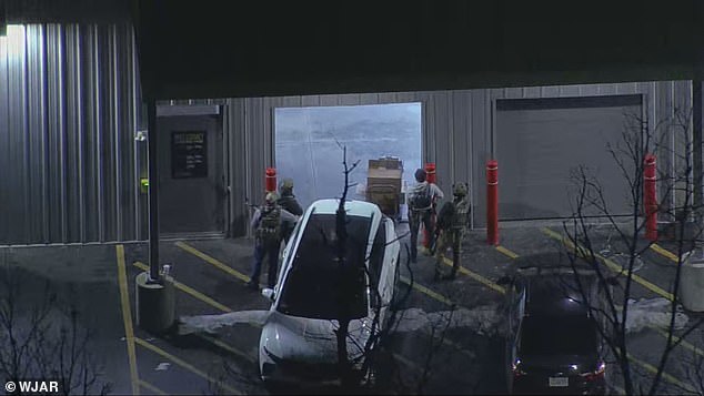 Armed police officers gathered outside of a storage facility in Salem, New Hampshire on Thursday, where a vehicle that was rented to the man suspected of opening fire at Brown University was found