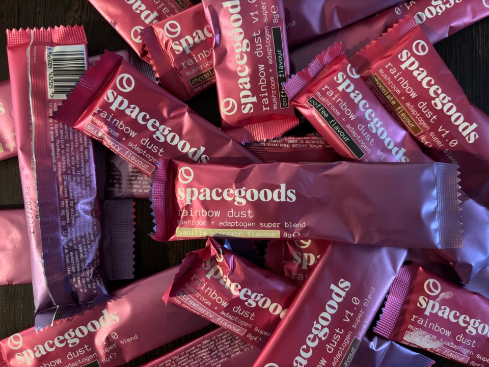 Spacegoods Rainbow Dust mushroom and adaptogen super blend packets in flavors including strawberry, vanilla cinnamon, coffee, and chocolate.